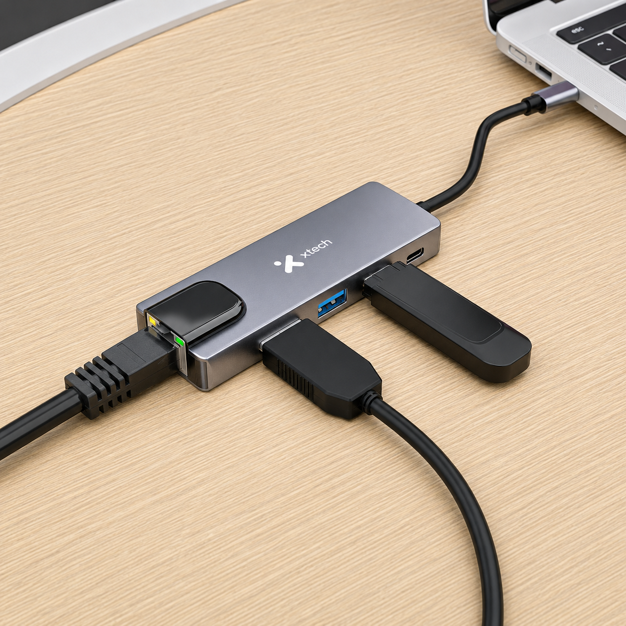 Hub Xtech XTC-572 conectado a laptop, cable Ethernet y dispositivos USB